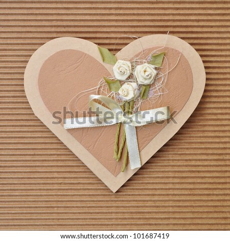 Handmade paper card love heart shape decorated with flowers and a bow brown colors.