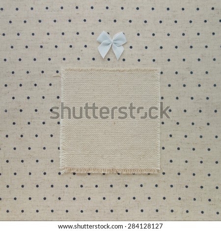Vintage book cover decorated with kiddy blue bow. Retro dotted pattern textile textured background.