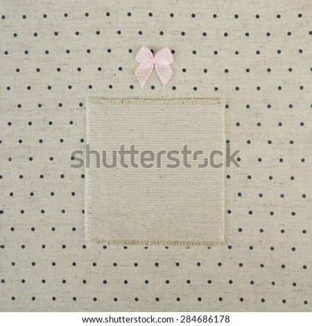 Vintage book cover decorated with kiddy pink bow. Retro dotted pattern textile textured background.