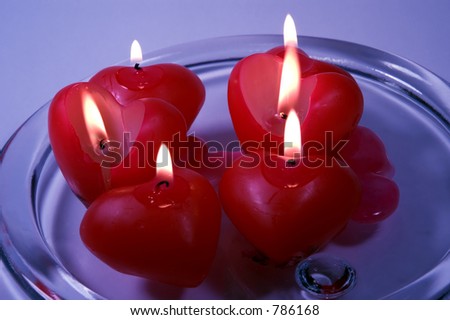 Wax candles in the shapes of hearts melting.