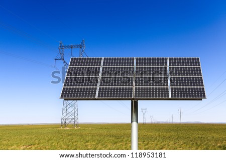 solar energy panel on the prairie with high voltage electricity transmission pylon background