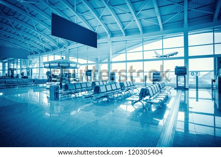 modern airport terminal waiting room with window outside scene of flight departure