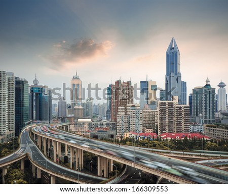 modern city skyline with elevated road junction and interchange overpass in shanghai at dusk