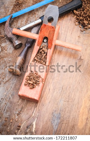 carpenter plane on the old wood with hammer , chisel and saw
