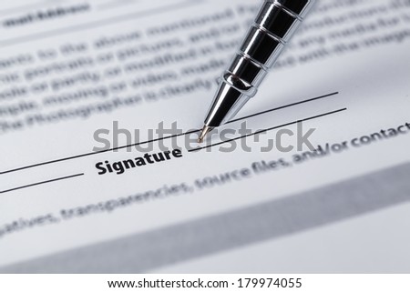 closeup of the signature and pen on a legal paper