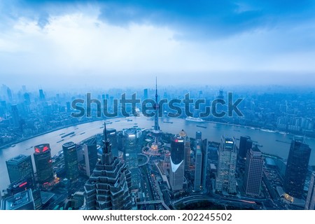 a bird\'s eye view of shanghai at dusk with cloudy sky