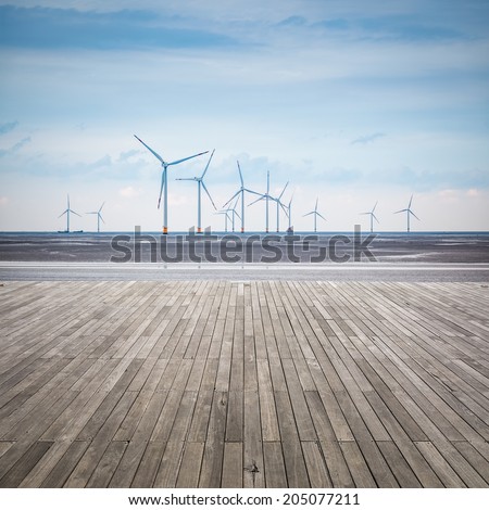 wind farm in mud flat with wooden floor ,develop shoals and renewable energy concept.