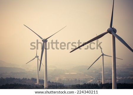 wind power generation turbine closeup at dusk in fog and haze