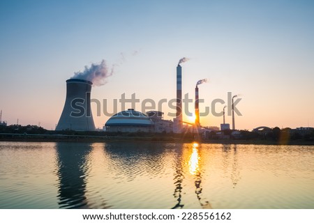 thermal power plant with the setting sun , industrial landscape