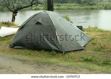 Tent on campsite by the river in rainy day