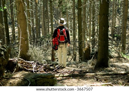A man standing in the forest, resting while trip