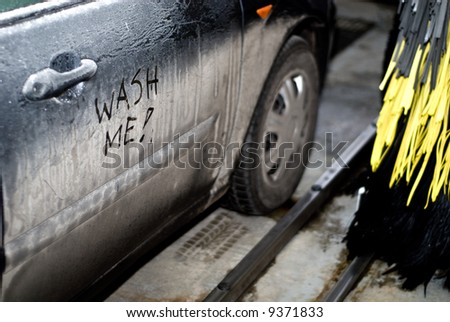 Interior of automatic car wash with dirty car (wash me sign)