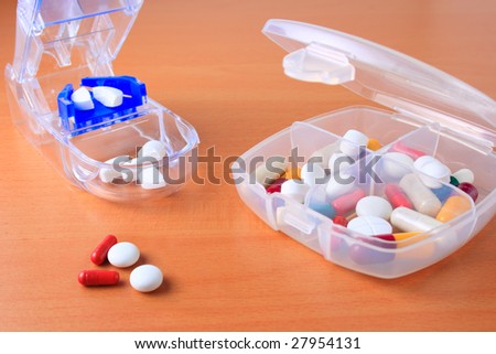 Assorted pills and capsules in pill organizer and pill cutter