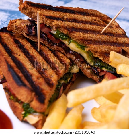 Sandwich of bread with bran with french fries, mozzarella, salad and bbq sauce