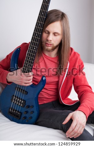 young guy playing guitar at home