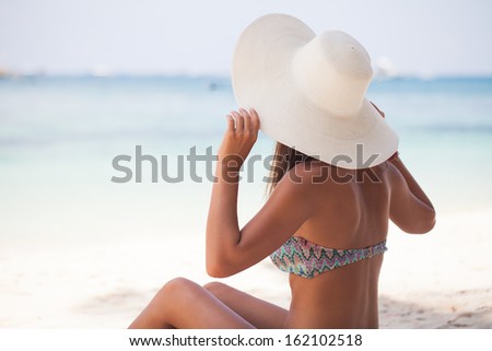 Beautiful woman sit on the sand at paradise beach