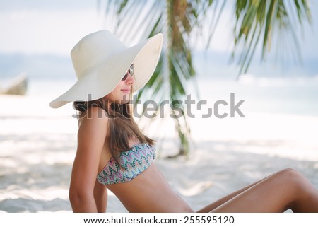 Beautiful woman sit on the sand at paradise beach