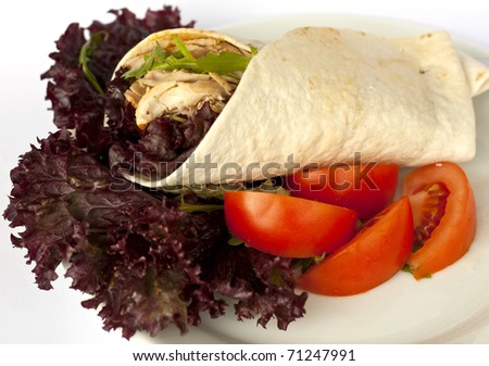 Delicious fresh and healthy chicken wrap with red lettuce and tomatoes