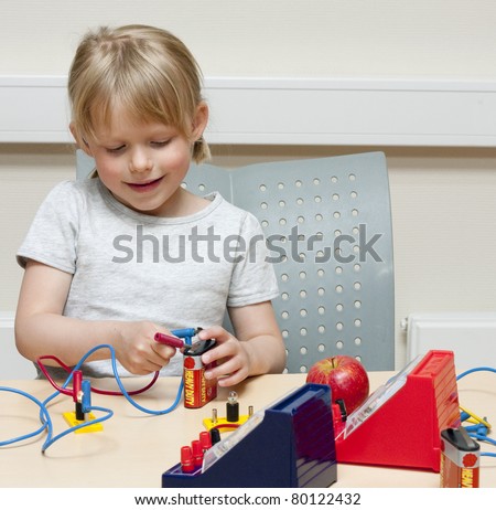 Cute little girl (5 years old) doing experiments with electricity