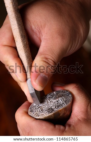 Chinese craftsman carving a stone seal