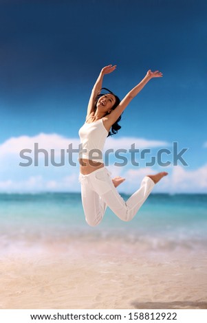 Woman jumping for joy at the beach