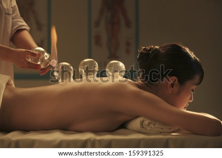 Chinese traditional herbalist doctor taking patient\'s pulse