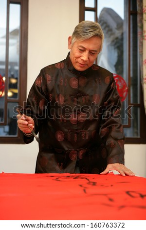 Chinese mature man writing Chinese couplet