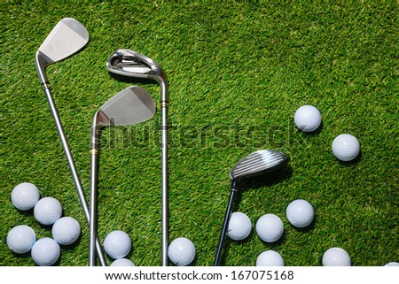 A shot of Golf balls and clubs on grass