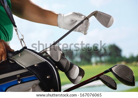 A shot of Golf player removing golf club from bag