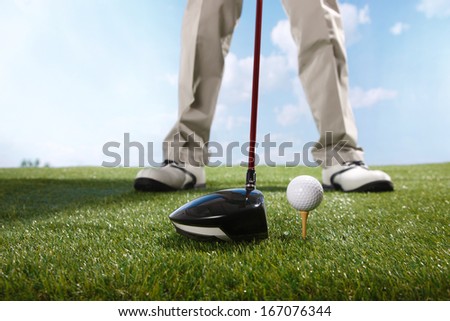 A shot of Golf player teeing up to hit ball