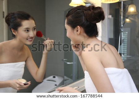 A shot of Young woman making-up in bathroom
