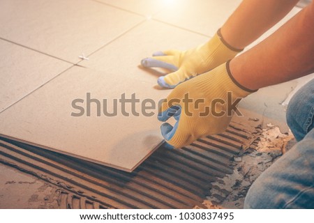 The tile glues the tile to the floor with a glue applied by a notched trowel