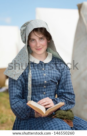 GETTYSBURG, PENNSYLVANIA - JULY 5: Young woman reading at reenactment commemorating the 150th anniversary of the Gettysburg Civil War battles on July 5, 2013 in Gettysburg, Pennsylvania