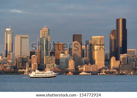 SEATTLE, WASHINGTON - AUGUST 3: A scenic cruise ship crosses in front of the Seattle skyline as viewed from Alki Beach Park on August 3, 2013 in Seattle, Washington