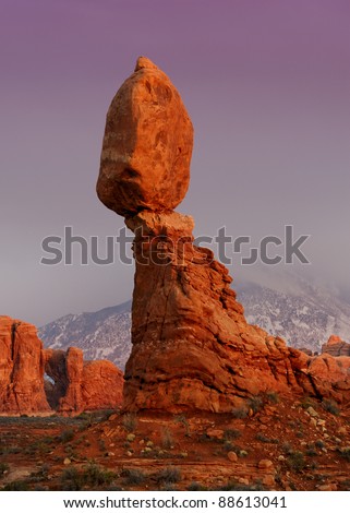 Balanced Rock at twilight in front of the snow covered La Sal Mountains in Arches National Park near Moab, Utah