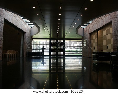 indoors of a modern architecture with reflection and a person looking out of the window