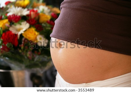 pregnant woman tummy with colorful flowers in the background