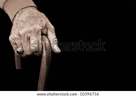 old man\'s hand with a walking cane