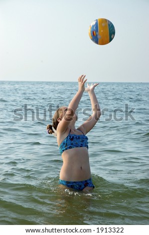 girl plays ball on seacoast