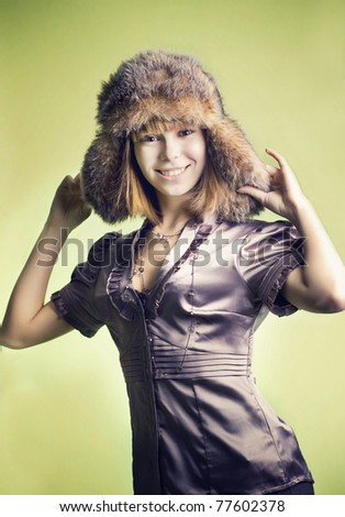 Portrait of the beautiful young girl in a fur cap