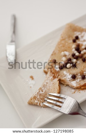 crepe of chocolate, with small balls of chocolate and places setting