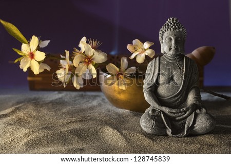 stone sitting buddha flowers and  Tibetan bowl