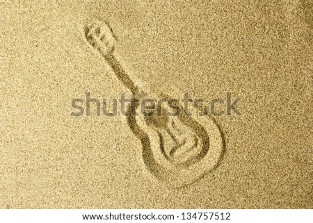 drawing hand guitar in the sand