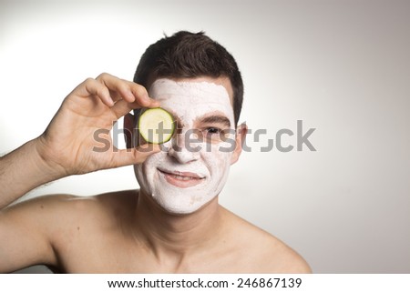man with clay facial mask in beauty spa