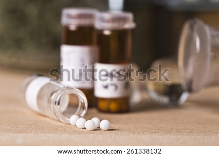 A homeopathy concept with homeopathic medicine (sugar/lactose pills and liquid homeopathic substances)