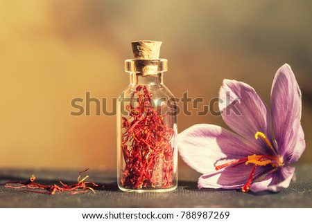 Dried saffron spice  in a bottle and Saffron flower