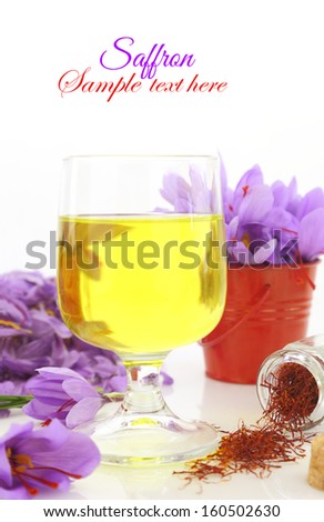 Glass off saffron tea and saffron flowers