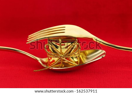 Christmas golden cutlery with ornament on red background