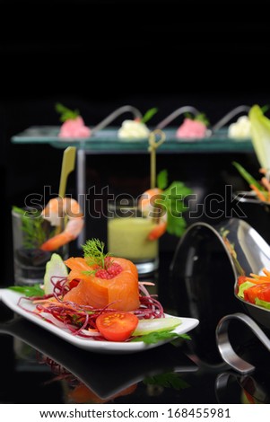 Smoked salmon with decoration and other dishes in background