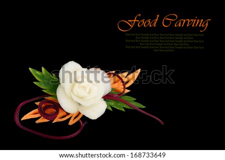 Decorative white flower carved from vegetable on black background